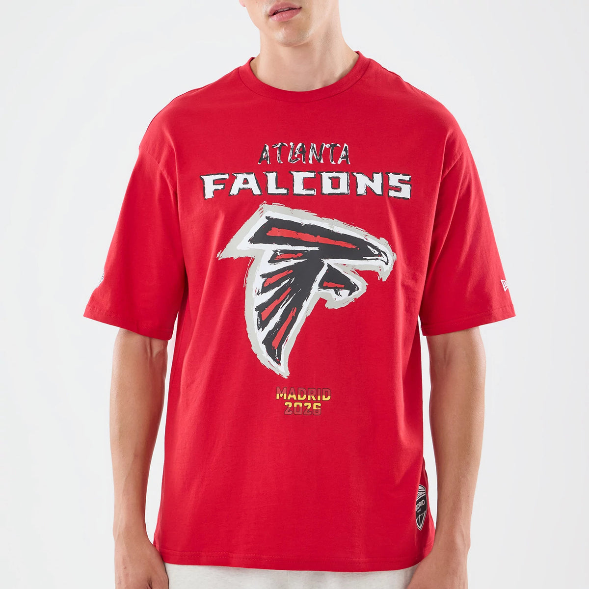 New Era Atlanta Falcons NFL Graphic Slogan Red Oversized T-Shirt, front view featuring a large Atlanta Falcons logo with lettering above, additional graphic detail below reading Madrid 2023.