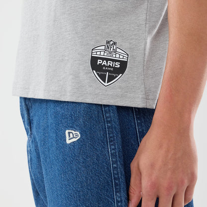 New Era New Orleans Saints NFL Graphic Slogan Grey Oversized T-Shirt, on-model side view showing a black and white Paris Game 2023 emblem printed at the lower hem, paired with blue jeans featuring an embroidered white New Era logo on the pocket.