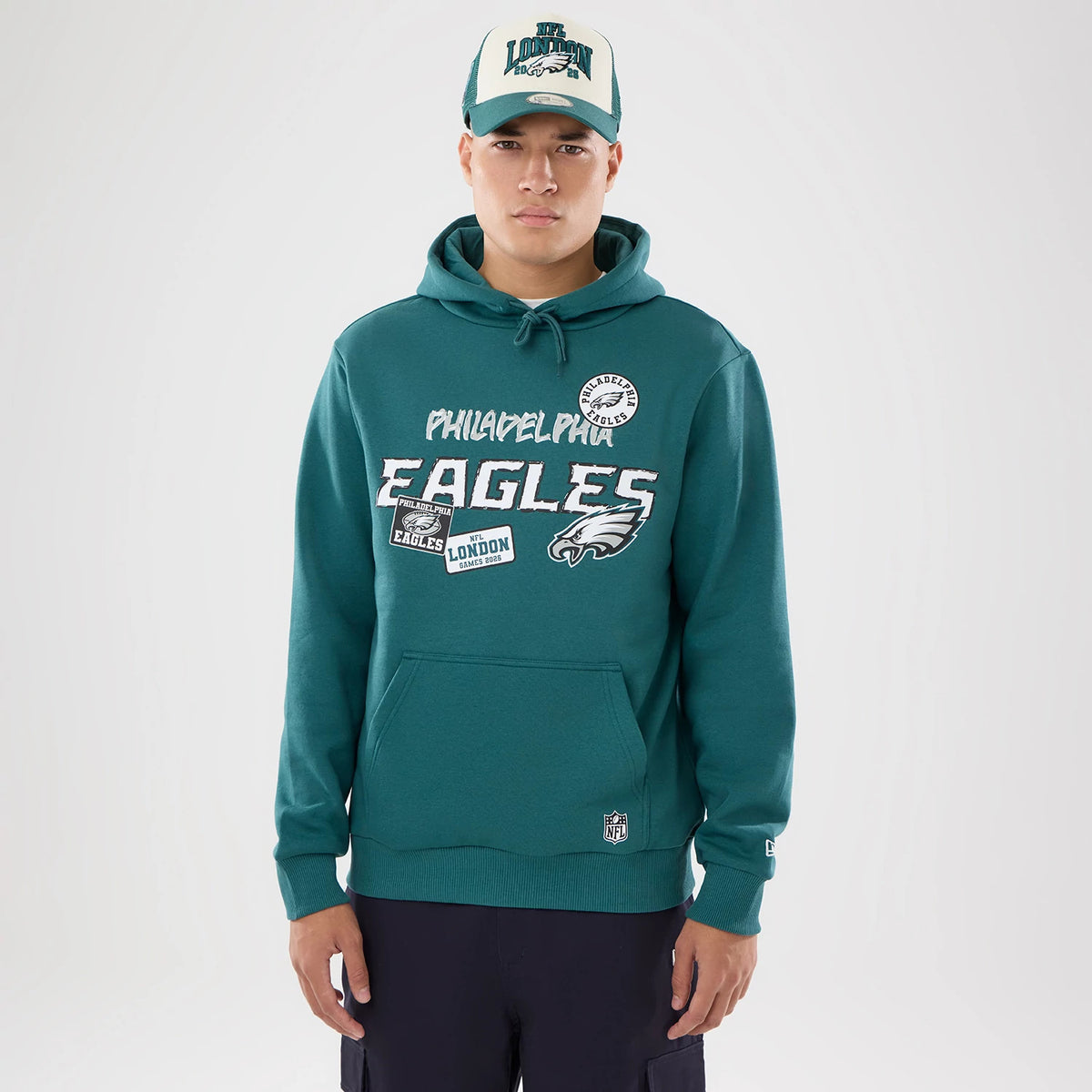 The model is wearing this NFL International Series Games 2026 Philadelphia Eagles Pullover Hoodie in dark green. 1