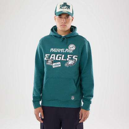 The model is wearing this NFL International Series Games 2026 Philadelphia Eagles Pullover Hoodie in dark green. 1