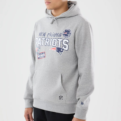 The model is wearing this NFL International Series Games 2026 New England Patriots Pullover Hoodie in grey. 3