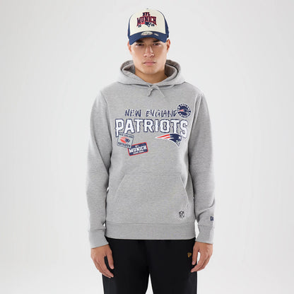 The model is wearing this NFL International Series Games 2026 New England Patriots Pullover Hoodie in grey. 1