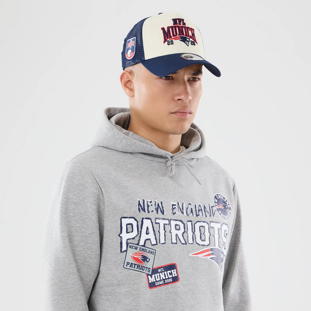 The model is wearing this NFL International Series Games 2026 New England Patriots Pullover Hoodie in grey. 6