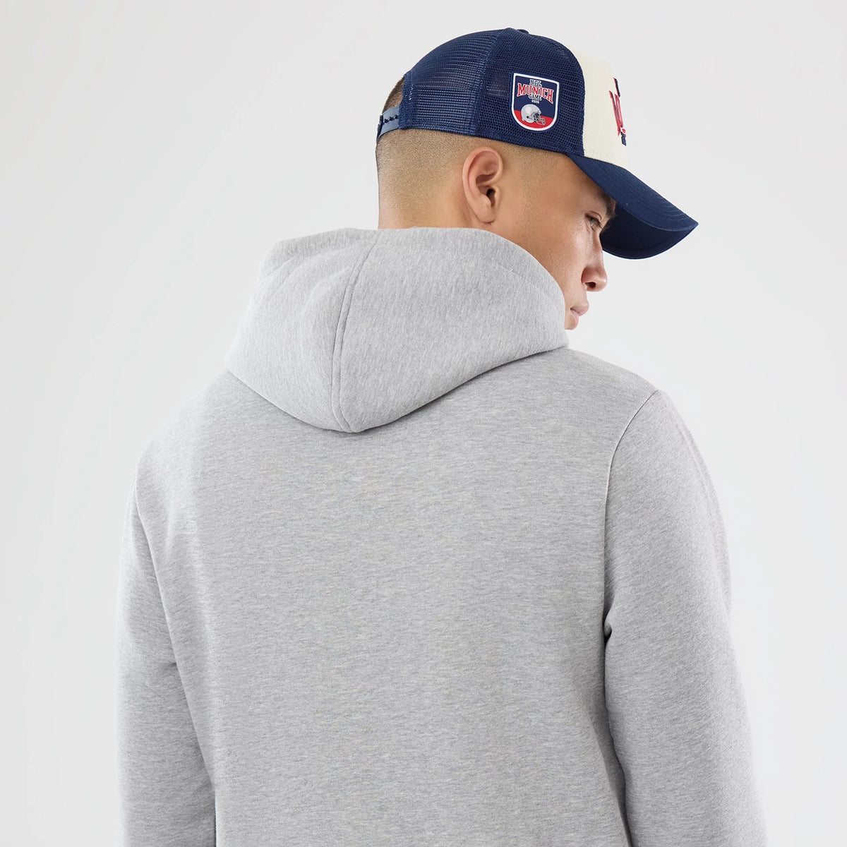 The model is wearing this NFL International Series Games 2026 New England Patriots Pullover Hoodie in grey. 7