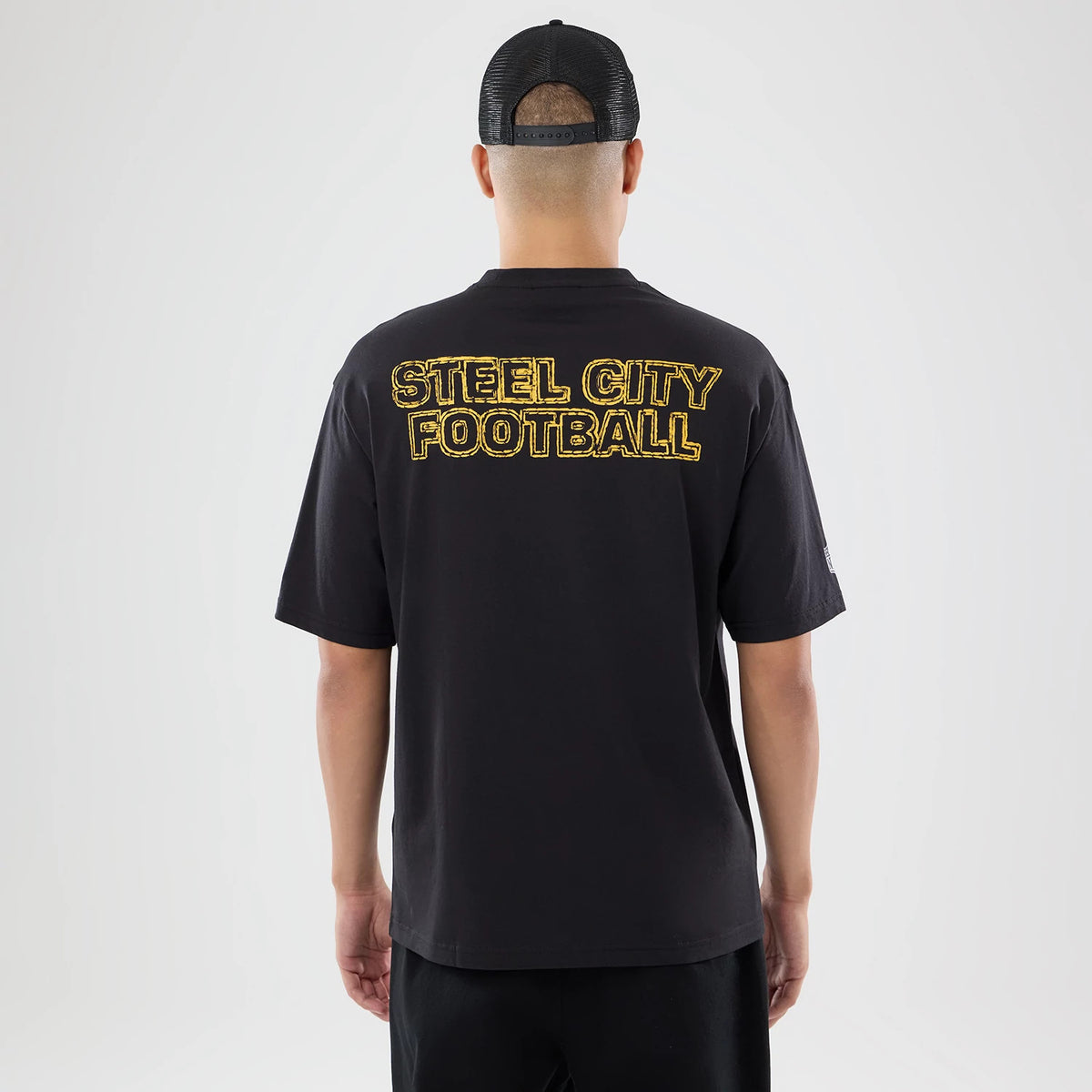 The model is wearing this NFL International Series Games 2026 Pittsburgh Steelers Oversized T-Shirt in black. 2