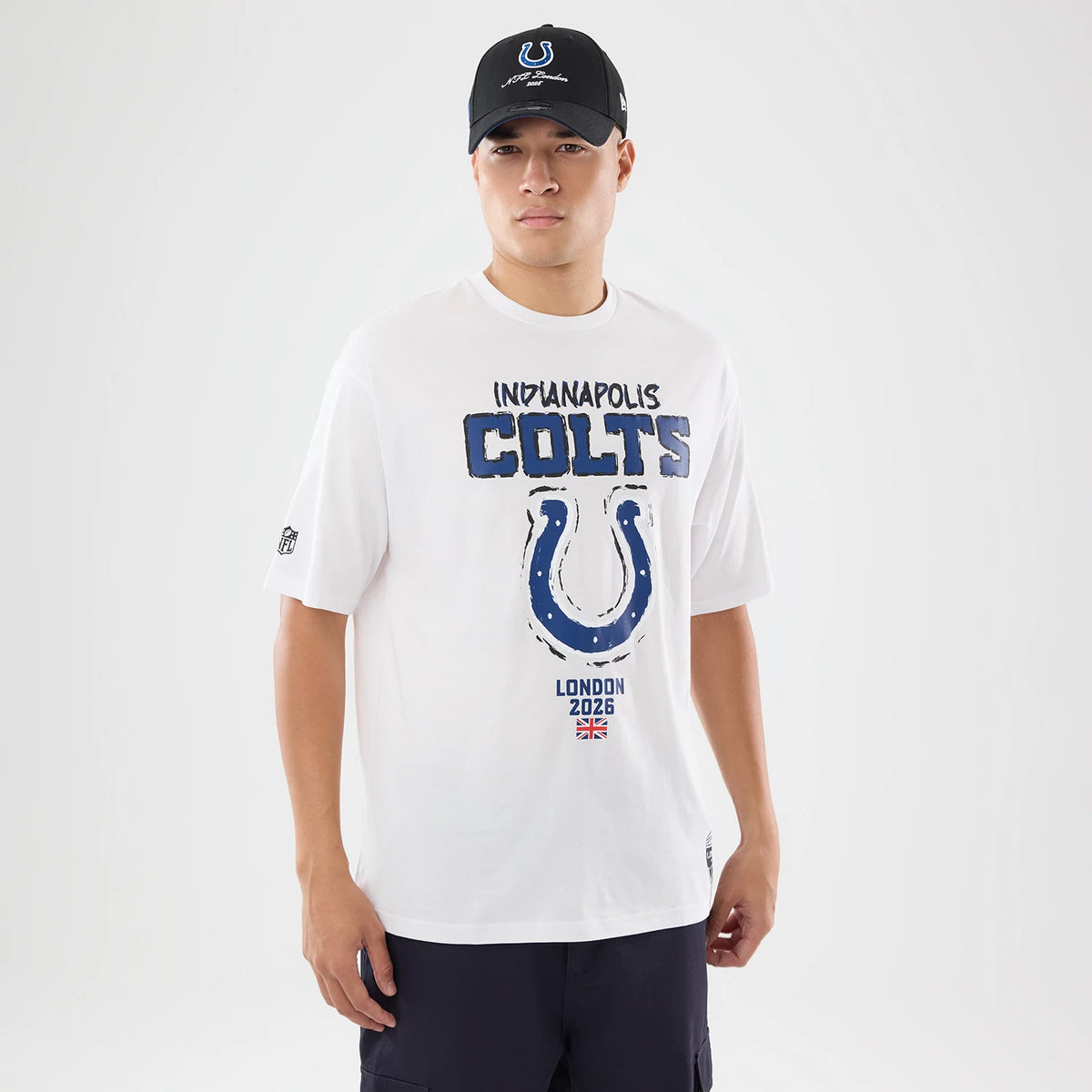 The model is wearing this NFL International Series Games 2026 Indianapolis Colts Oversized T-Shirt in white. 1
