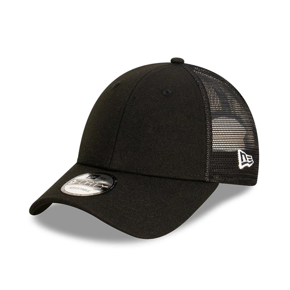 New Era Blank Black 9FORTY Trucker Cap, three-quarter view showing the curved black visor with a 9FORTY size sticker, structured black front panel with black mesh back panels, and the embroidered New Era flag logo on the left side.