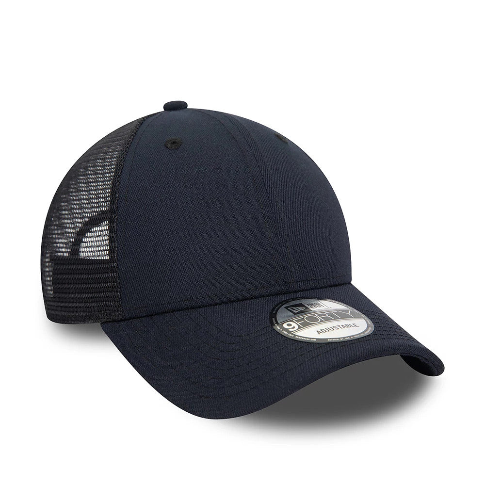 New Era Blank Navy New Era 9FORTY Trucker Cap, three-quarter view with a curved navy visor featuring a 9FORTY size sticker, structured front panels, and breathable mesh back panels for a balanced and look.