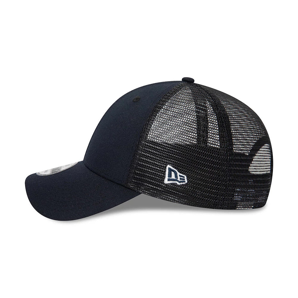 New Era Blank Navy 9FORTY Trucker Cap, side view with the white embroidered New Era flag logo on the black mesh panels, showcasing the navy curved visor and structured front panels, along with the 9FORTY size sticker on the visor.