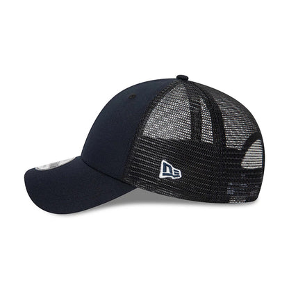 New Era Blank Navy 9FORTY Trucker Cap, side view with the white embroidered New Era flag logo on the black mesh panels, showcasing the navy curved visor and structured front panels, along with the 9FORTY size sticker on the visor.