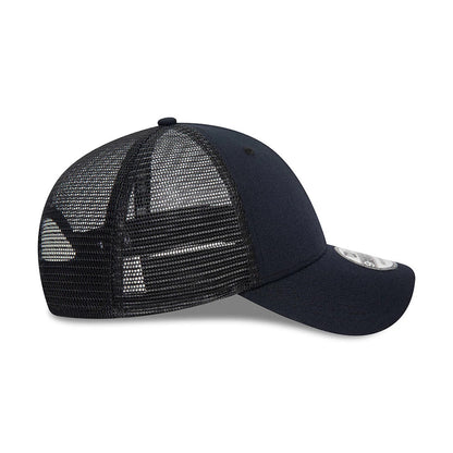 New Era Blank Navy New Era 9FORTY Trucker Cap, side view showing the black mesh back panels extending to the structured navy front, with the curved visor and attached 9FORTY size sticker above the visor.