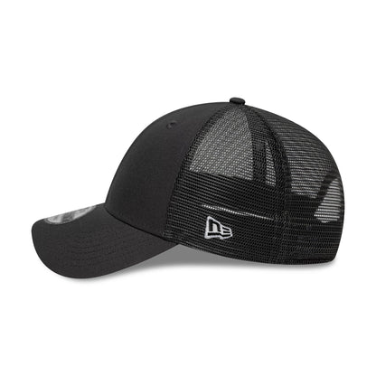 New Era Grey 9FORTY Trucker Adjustable Cap, side view showing the white embroidered New Era flag logo on the mesh back panel, with a curved black visor and black 9FORTY size sticker on the bill.
