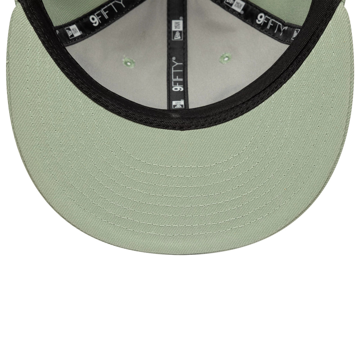 New Era Green Retro Crown 9FIFTY Snapback Adjustable Cap, inside view showing a mint green undervisor with detailed stitching, black taping with white 9FIFTY branding throughout, and green eyelets on the inner panels of the structured crown.
