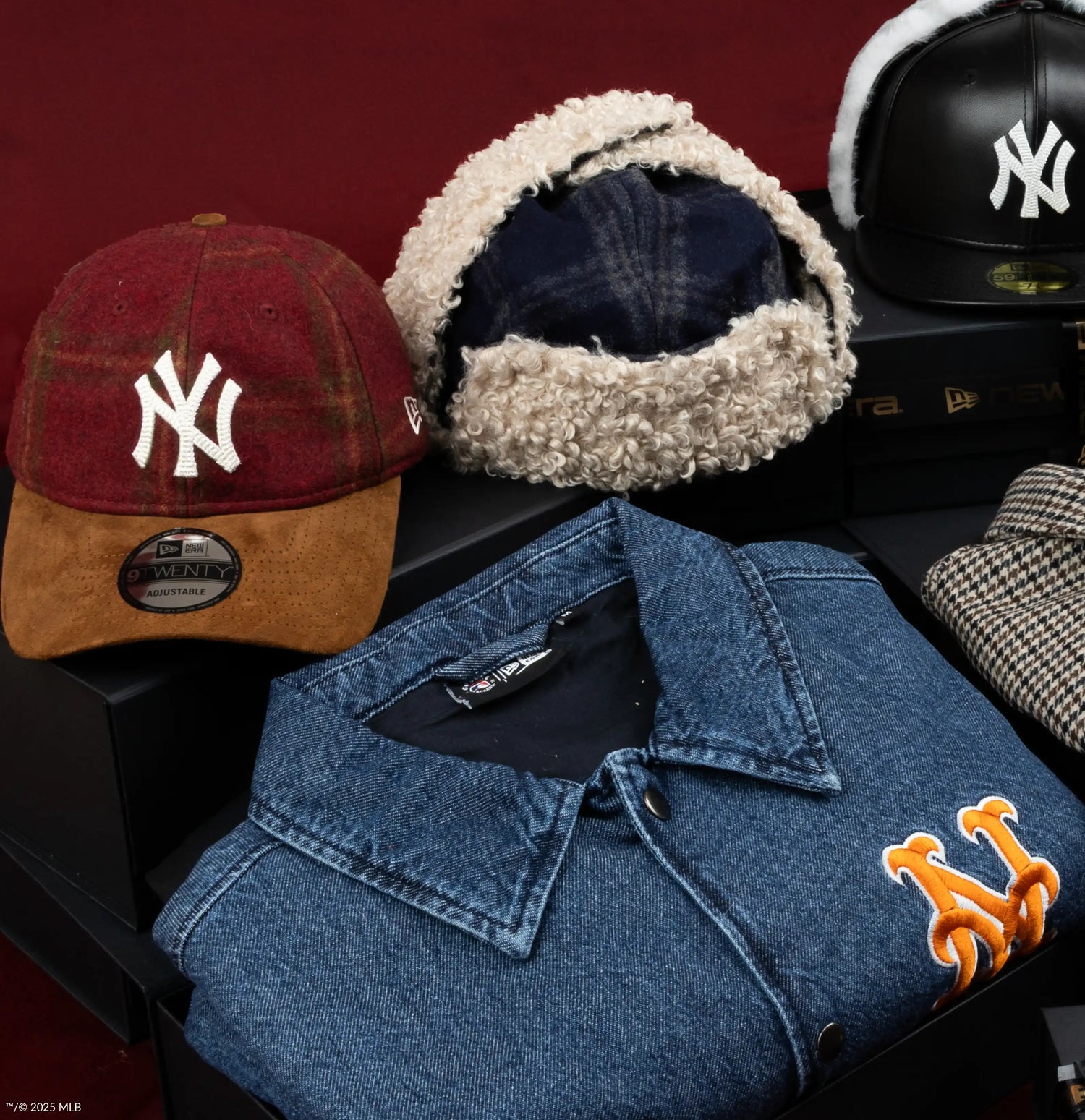 Collection of New York Yankees merchandise including a cap, jacket, and ear muffs on a dark surface.