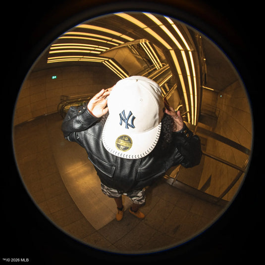 Person wearing a New York Yankees 59fifty cap in a tunnel with reflective ceiling