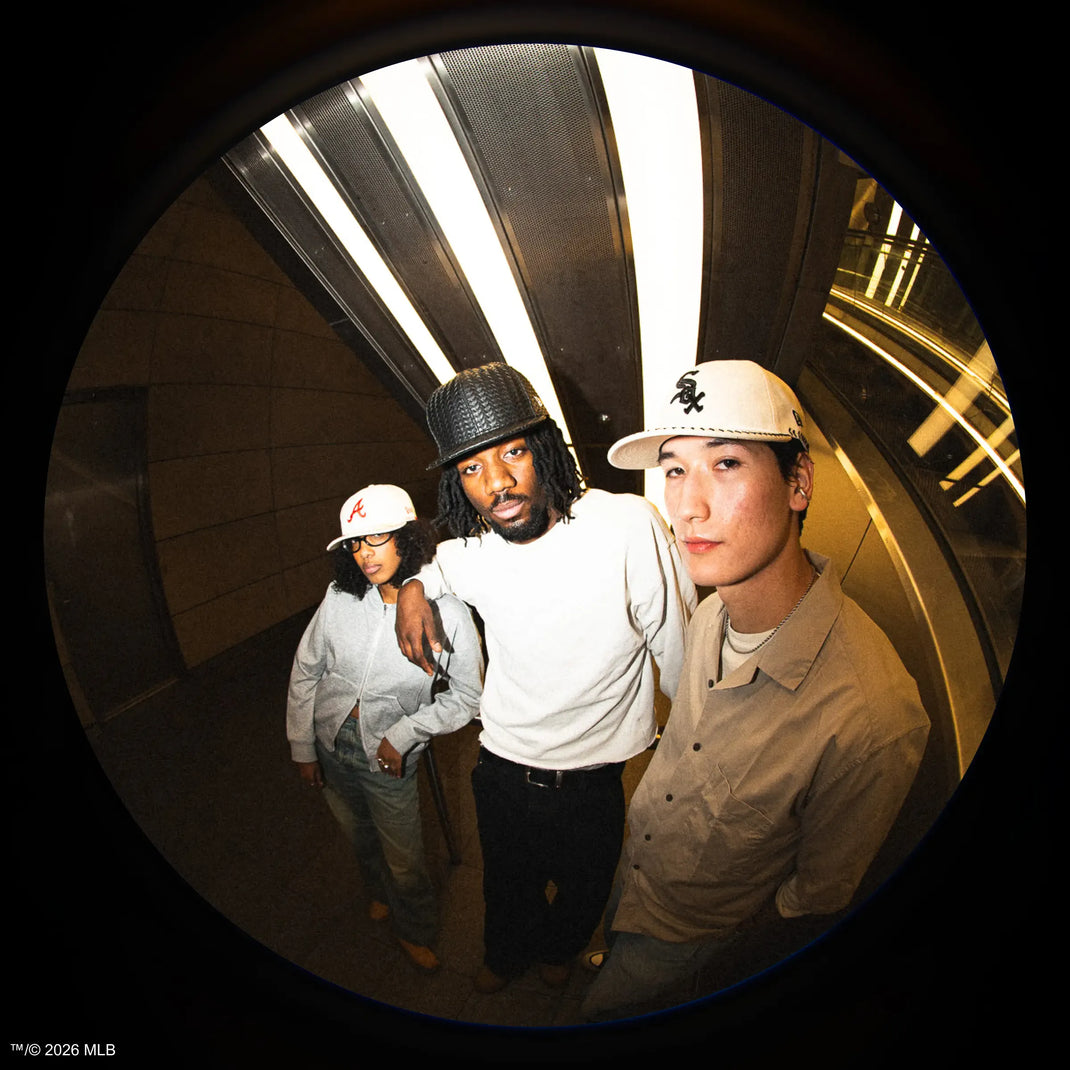 Three people posing together in a tunnel wearing 59fifty caps with a fisheye lens effect.