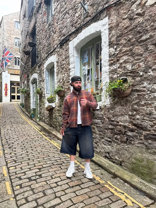 Slide 2:Man standing on a cobbled street in an urban setting with stone buildings.